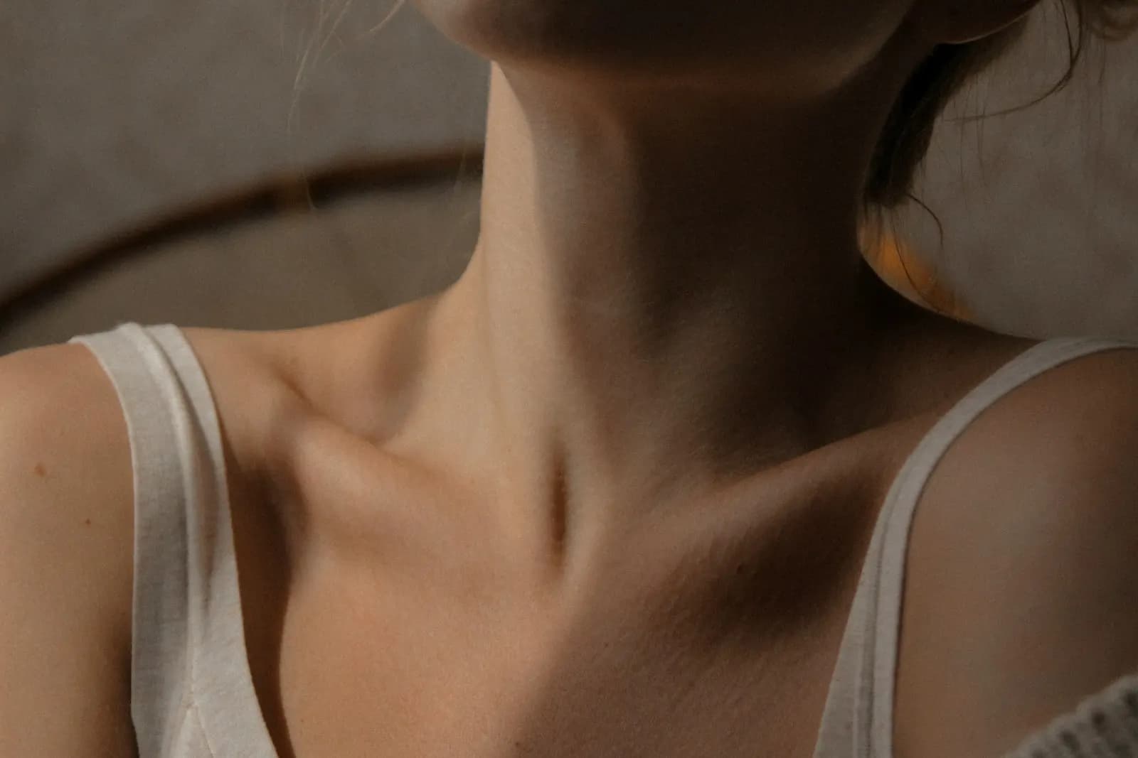 Cuello y clavículas de una mujer con una camiseta de tirantes
